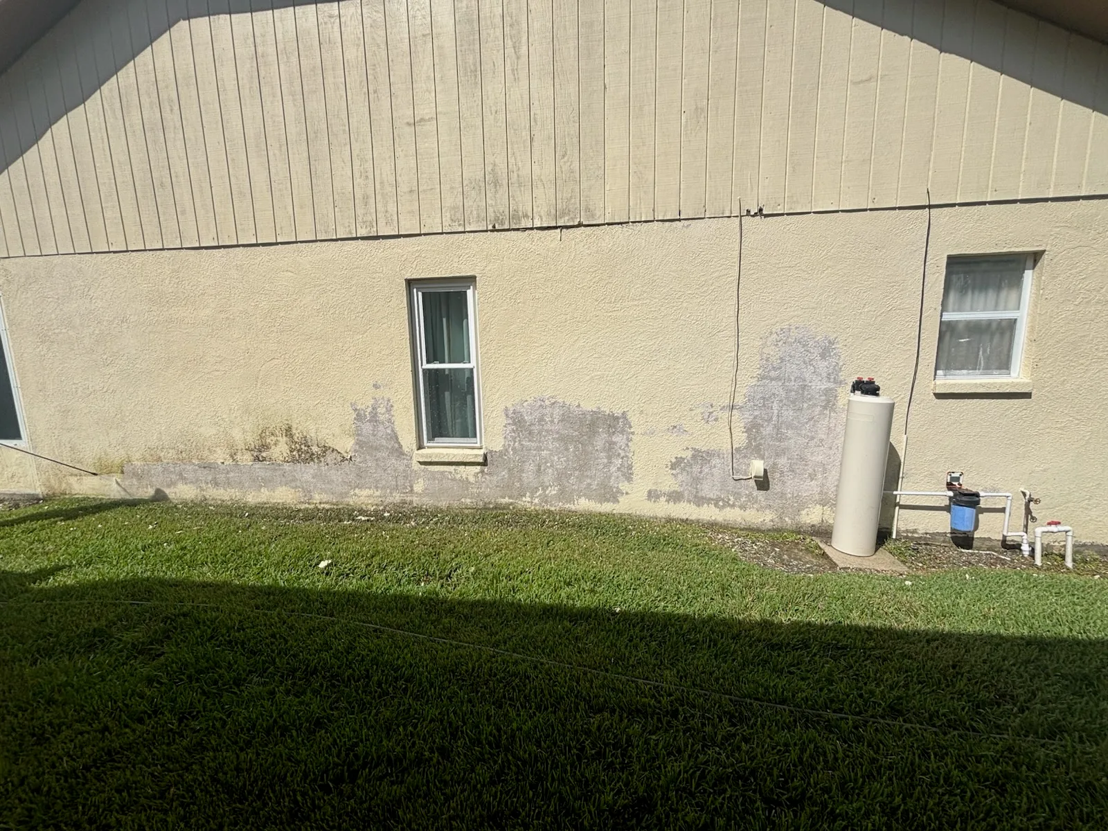 Before front view of the same stucco house shown in the after photo